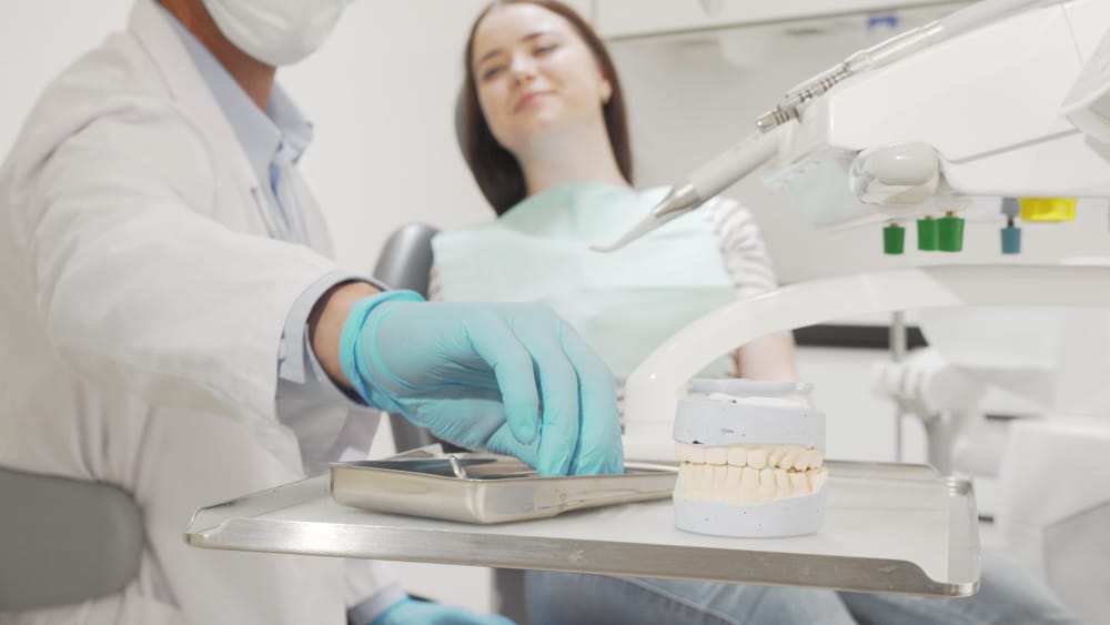 Professional dentist examining teeth of a female patient - Orthodontic Treatment Professional dentist examining teeth of a female patient - Orthodontic Treatment